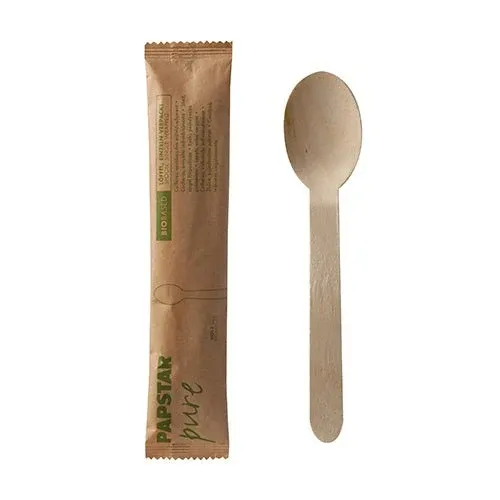 Ein PAPSTAR Holzlöffel "pure" 16 cm, einzeln im Papierbeutel verpackt, sowie dessen braune Verpackung mit "PAPSTAR pure"-Label sind nebeneinander vor weißem Hintergrund zu sehen.