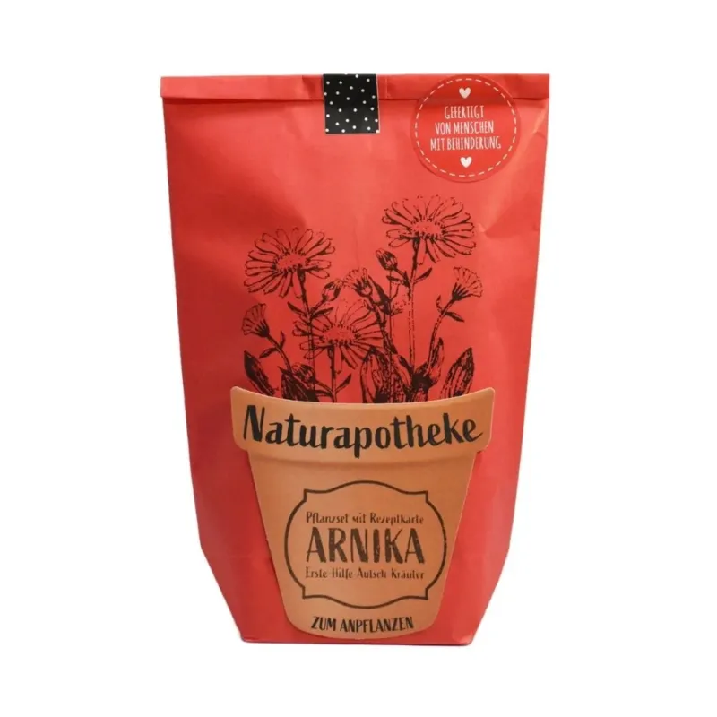 Rote Wundertüte mit einem aufgeklebten Topf auf dem "Naturaphotheke Pflanzset ARNIKA" steht. Aus dem Topf sind aufgedruckte Blumen