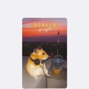 Postkarte mit Hamster und Kopfhörern vor Berliner Skyline im Sonnenuntergang mit Schriftzug "BERLIN at night"